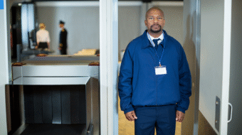 airport-security-officer-standing-metal-detector-door