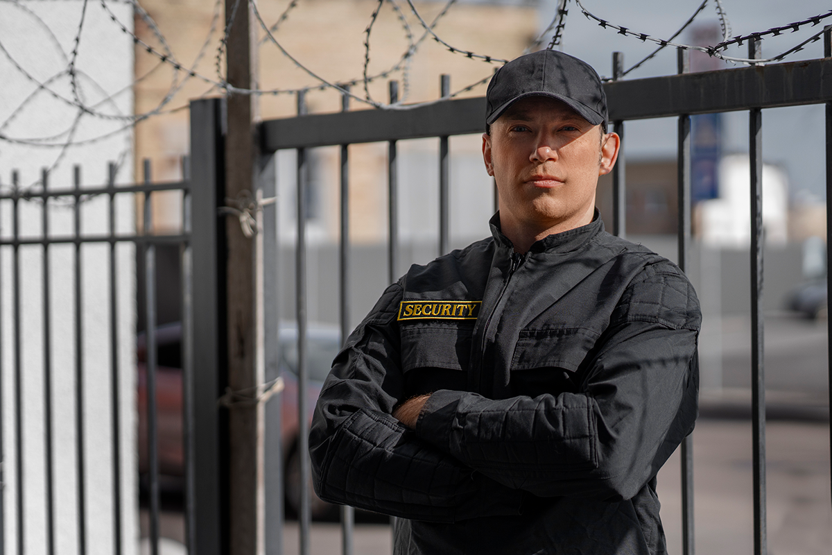 portrait-male-security-guard-with-barbed-wire-fence