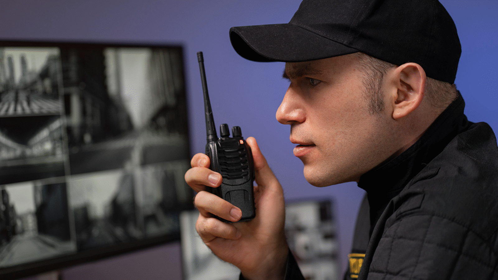 portrait-male-security-guard-with-radio-station-camera-screens